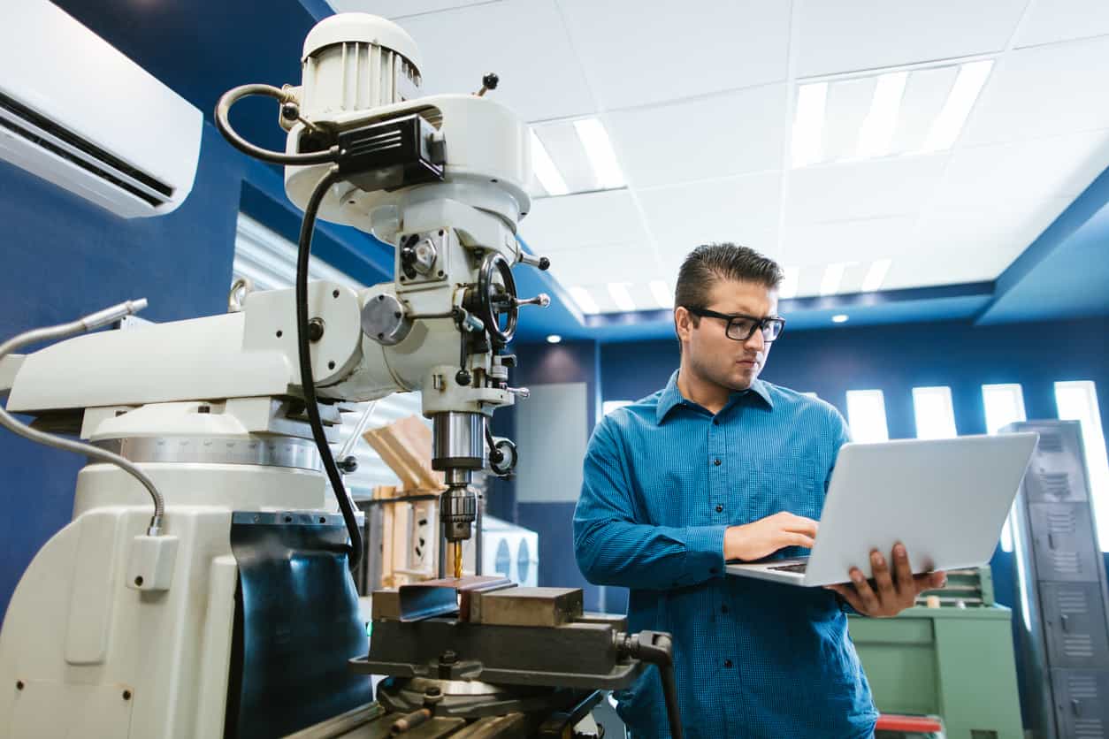 工程師於 CNC 車床設備旁使用筆電進行精密機械加工設定,呈現智慧製造與加工監控流程。 - 高效 CNC車床 | 精密機械設備解決方案 | 重研機械有限公司 工程師於 CNC 車床設備旁使用筆電進行精密機械加工設定,呈現智慧製造與加工監控流程。
